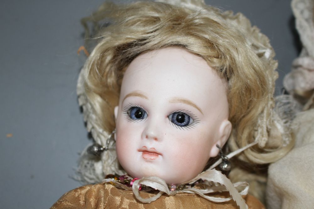 A Simon and Halbig bisque head doll with fixed blue eyes, pierced mouth and pierced ears, no.1250/4½, an unmarked bisque head doll,